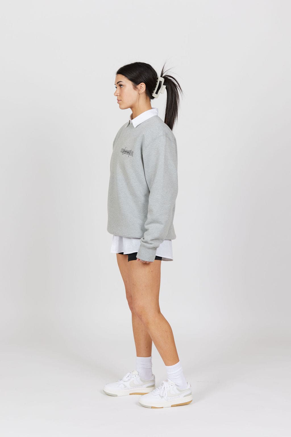 Side view of female model wearing the Grey Marl Collective Crew Neck Top