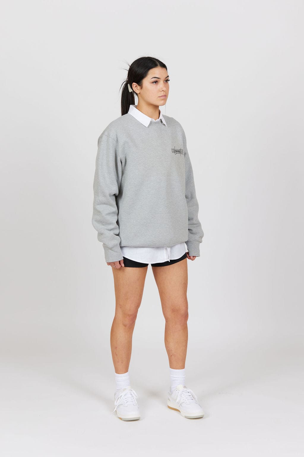 Side view of female model wearing the Grey Marl Collective Crew Neck Top