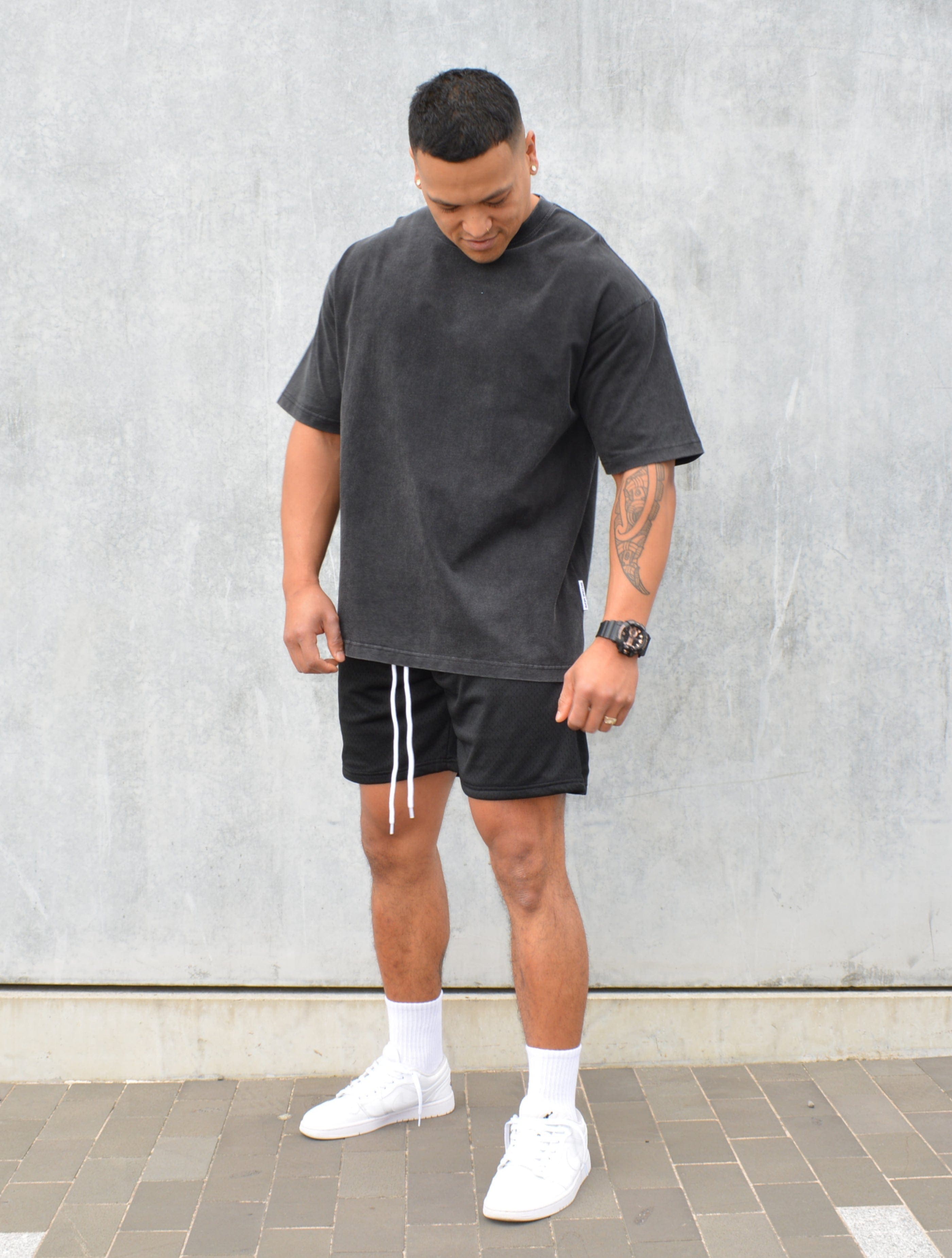 Still Image of our Male model wearing our Black Washed Staple Tee